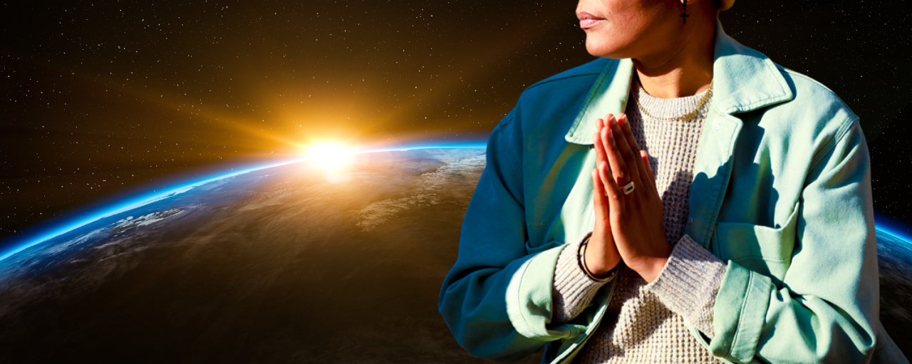 A photo of V Woods sitting hands together at heart, floating in space with the curvature of earth in the background